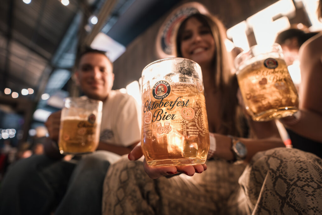Gäste feiern bei Live-Musik und bayerischer Stimmung im Mercado in Altona mit Bierkrügen